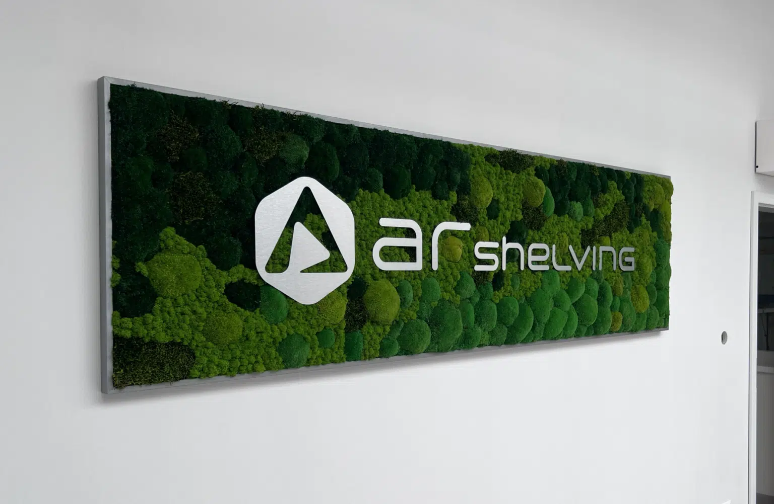 Machová stena s bielym logom spoločnosti AR Shelving